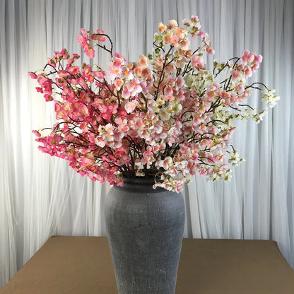 Infuse timeless serenity with these 40in Artificial Cherry Blossom Stems. Lifelike faux sakura branches bring ethereal Japanese elegance to weddings or homes.