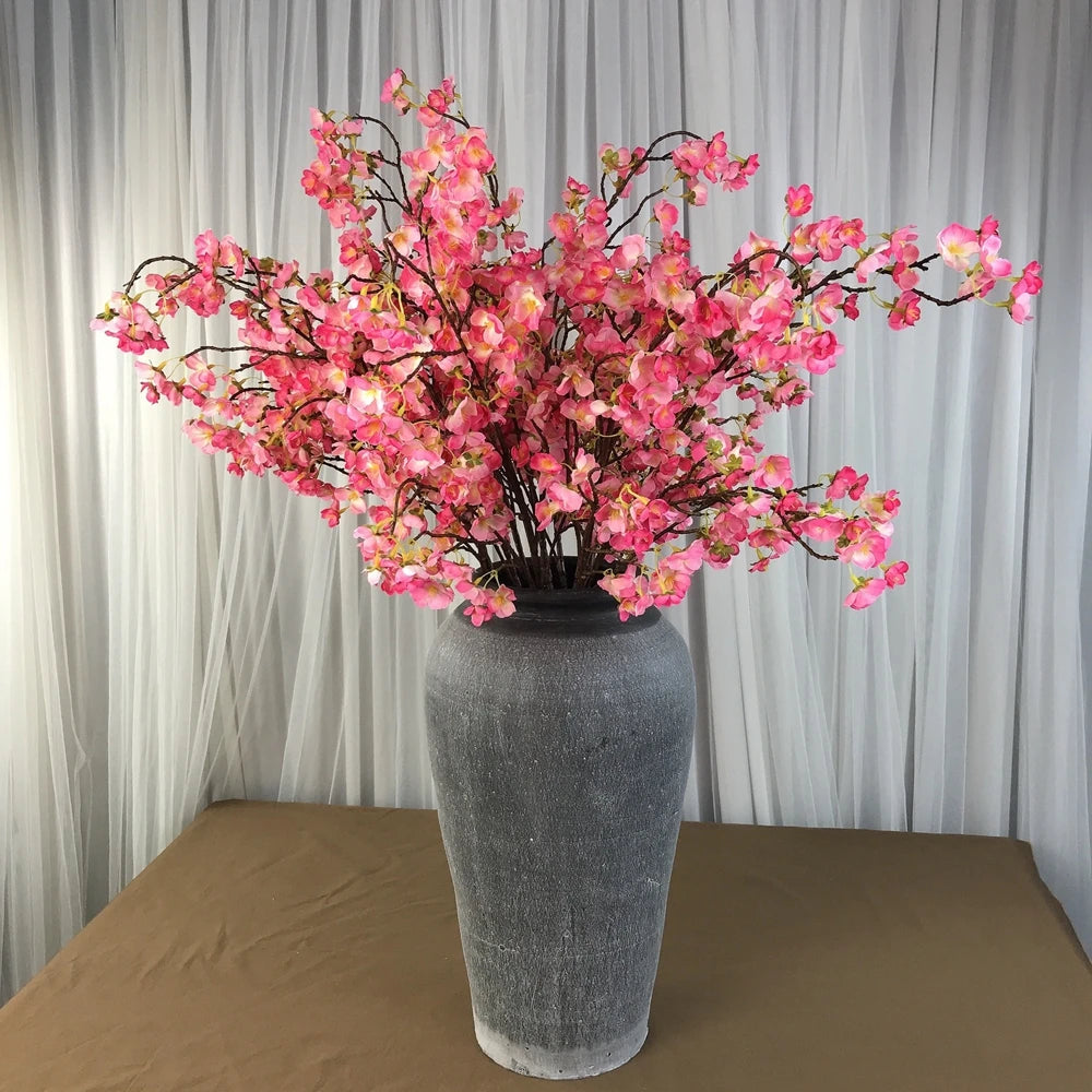 Infuse timeless serenity with these 40in Artificial Cherry Blossom Stems. Lifelike faux sakura branches bring ethereal Japanese elegance to weddings or homes.