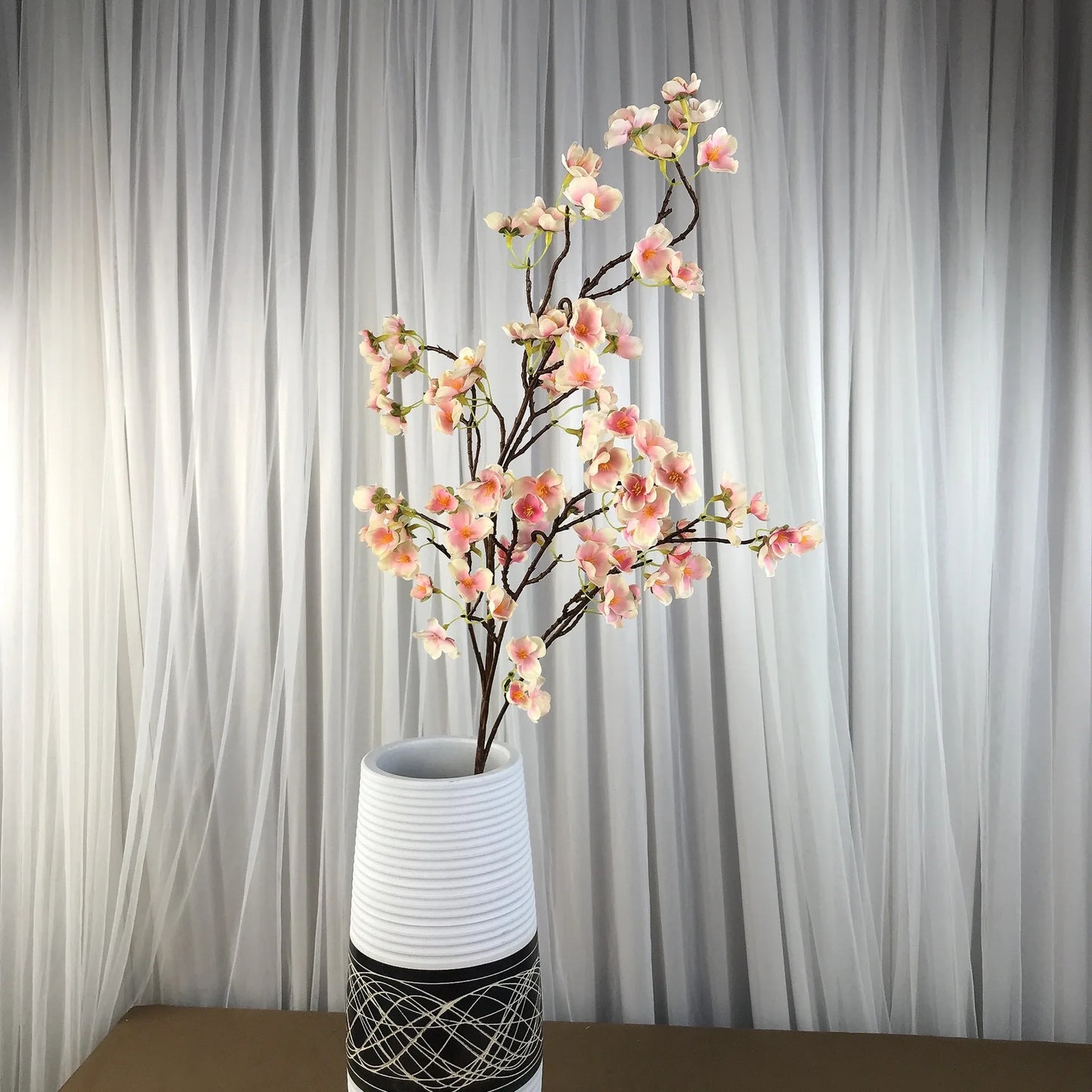 Infuse timeless serenity with these 40in Artificial Cherry Blossom Stems. Lifelike faux sakura branches bring ethereal Japanese elegance to weddings or homes.